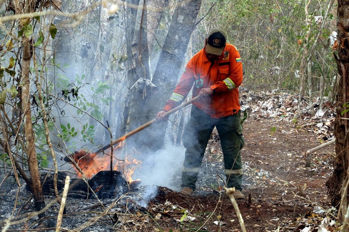 Un bombero mitiga los restos de un incendio⁢ este miércoles, San Miguelito (Bolivia). Foto EFE