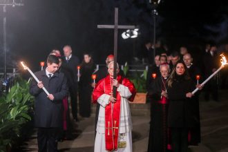 El Papa León XIV lleva la cruz en un Vía Crucis por la paz